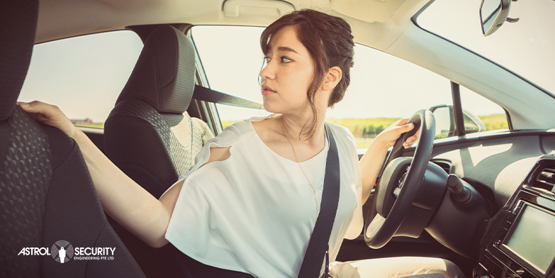 woman looking back while reversing her car